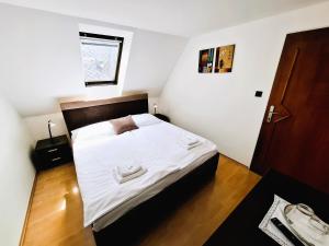 a bedroom with a large bed with white sheets at Penzion PANDA Tourist in Turčianske Teplice