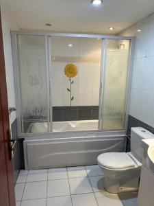 ハルガダにあるPanoramic Sea Viewのトイレと壁に黄色い花が飾られたバスルーム +5枚の写真