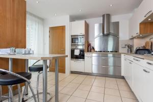 a kitchen with stainless steel appliances and a table at Panorama - 180-Degree Harbour Views in Poole