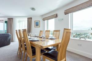 a dining room with a wooden table and chairs at Panorama - 180-Degree Harbour Views in Poole