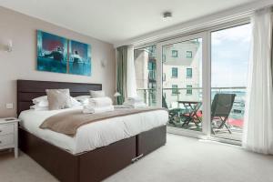 a bedroom with a large bed and a large window at Panorama - 180-Degree Harbour Views in Poole