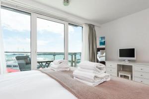a bedroom with a bed with a view of the ocean at Panorama - 180-Degree Harbour Views in Poole +21 photos
