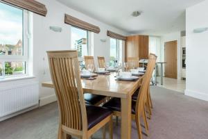 a dining room with a wooden table and chairs at Panorama - 180-Degree Harbour Views in Poole