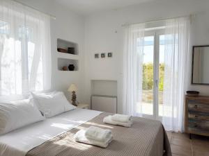 a bedroom with a bed with two towels on it at Sunny House in Pounda