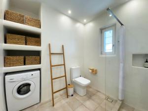 a bathroom with a washing machine and a toilet at Sunny House in Pounda +40 photos