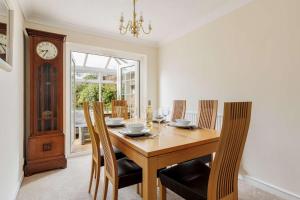 a dining room with a table and chairs and a clock at Chimneys - Old Town Poole Location, with Garden and Garage in Poole