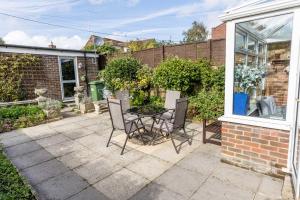 a patio with a table and chairs in a yard at Chimneys - Old Town Poole Location, with Garden and Garage in Poole
