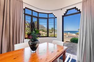 a dining room with a table and a large window at Camps Bay Village in Cape Town +120 photos