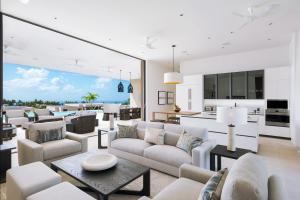 a living room with white furniture and a view of the ocean at Apes Hill Barbados Golf and Resort Community in Saint James
