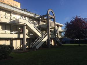 a building with a spiral staircase in front of it at Premiere Classe Evreux in Évreux