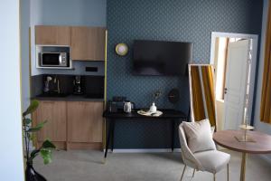 a living room with a table and a microwave at DOMITYS - Les Trèfles in Châtellerault