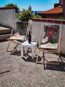 two chairs and a table with a bottle of wine at Villa Terraca in Mandre