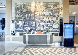 eine Wand in einem Raum mit einem Tisch mit Blumen darauf in der Unterkunft Urban Chic Studio at Amor Apartment in Pakuwon City Mall, East Surabaya by Le Ciel Hospitality in Surabaya + 33 Fotos