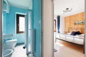 a bedroom with blue walls and a bed and a sink at Residence Madamin in Fenestrelle +145 photos