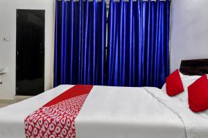 a bedroom with a bed with red and blue curtains at Hotel O SESHADRI HOMESTAY in Tirupati +43 photos