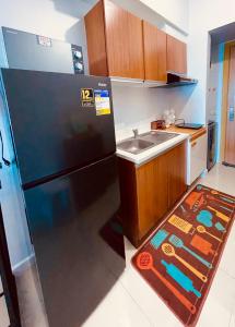 a kitchen with a black refrigerator and a sink at 8 Adriatico- 1 Bedroom Condo with Balcony in Ermita near US Embassy in Manila