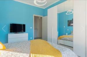 a bedroom with blue walls and a bed with a television at Loano Centro - A pochi passi dal Mare e dalla Stazione in Loano