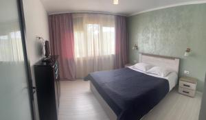a bedroom with a blue bed and a window at City Center TT in Piatra Neamţ
