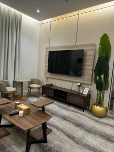 a living room with a flat screen tv on a wall at شقة فندقية من غرفة و صالة مع بالكونة مطلة in Jeddah