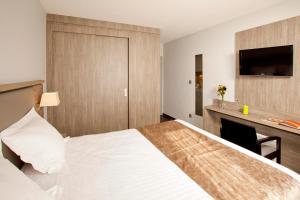 um quarto de hotel com uma cama e uma lareira em Séjours & Affaires Grenoble Marie Curie em Grenoble