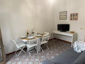 un salon avec une table et un bureau dans l'établissement 50mt from sea Villetta White 2 bedr outdoor, à Marina di Pietrasanta