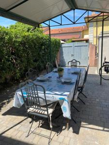 une table avec des chaises assises sous un parasol dans l'établissement 50mt from sea Villetta White 2 bedr outdoor, à Marina di Pietrasanta
