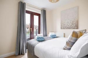 a bedroom with a bed with blue pillows on it at Harbour Hideaway - Moments from the Wide-Open Spaces of Harbourside Park in Poole