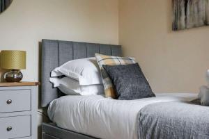 a bedroom with a bed with white sheets and pillows at Harbour Hideaway - Moments from the Wide-Open Spaces of Harbourside Park in Poole