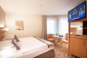 pokój hotelowy z łóżkiem i telewizorem w obiekcie Lotus Therme Hotel & Spa w Hévízie