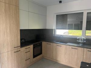 a kitchen with wooden cabinets and a window at Strefa Natur dom z jacuzzi na wyłączność in Matyty