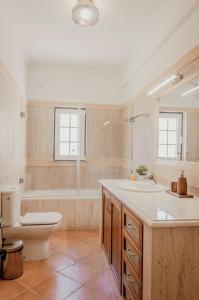 a bathroom with a tub and a toilet and a sink at Casa dos Almargens - Moradia 3 quartos com piscina in São Brás de Alportel