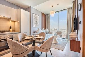 a kitchen and living room with a table and chairs at STAY BY LATINEM Luxury 1BR Holiday Home W 2709 Near Burj Khalifa in Dubai