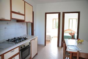 a kitchen with a stove and a sink and a table at Villaggio Bellariva in Peschici