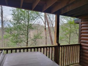 a screened in porch with a bed and a large window at Simply Charming in Pigeon Forge