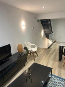 a living room with a tv and a couch and a table at La casita de la plaza in Plasencia
