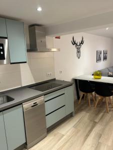 a kitchen with a stove and a table with chairs at La casita de la plaza in Plasencia