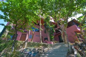 una casa rosa con escaleras que conducen a ella en Biancas Garden Apartments Boracay, en Boracay