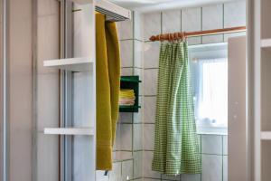 baño con toallas verdes y cortina de ducha en Möve Aba Bungalow 61, en Rerik