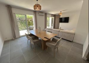 a dining room with a table and chairs and a couch at L'étang au soleil in Berre-lʼÉtang