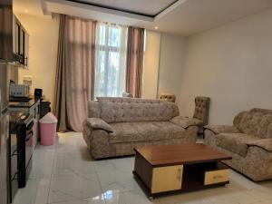 Wintana Apartments Kigali في كيغالي: غرفة معيشة مع أريكتين وطاولة قهوة