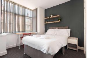 a bedroom with a large white bed and a window at Spacious 4 Bedroom House with Garden in Doncaster in Doncaster