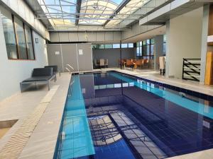 Wintana Apartments Kigali في كيغالي: مسبح كبير وبلاط ازرق في مبنى