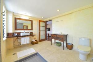 Un baño con inodoro, lavabo y espejo. en Biancas Garden Apartments Boracay, en Boracay 119 fotos más