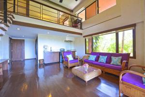 a living room with a purple couch and a table at Biancas Garden Apartments Boracay in Boracay