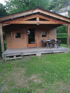 a cabin with a table and chairs on a porch at Camping Onlycamp Les Adoubes - Albertville in Albertville