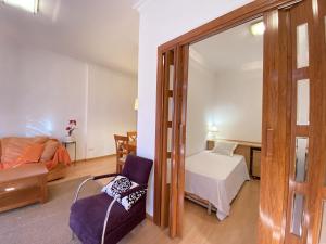 TH61 Apartamento vacacional Plaza de la Font في تاراغونا: غرفة بسرير ومرآة