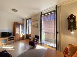 TH61 Apartamento vacacional Plaza de la Font في تاراغونا: غرفة معيشة مع تلفزيون ونافذة كبيرة