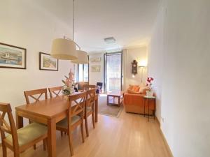 TH61 Apartamento vacacional Plaza de la Font في تاراغونا: غرفة طعام وغرفة معيشة مع طاولة وكراسي