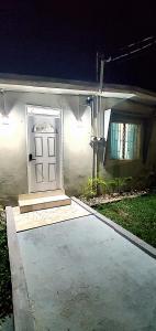 a white door in a white house at night at Hughenden couples oasis and family retreat in Kingston