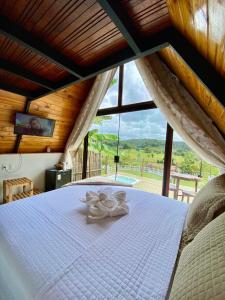 a bedroom with a bed with a large window at Rancho Navarro - Cabana A-Frame in Pôrto de Pedras +92 photos